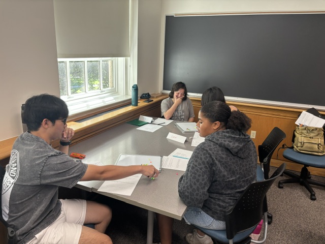 Another team of four breaks into two groups of two to play the bead game and try to figure out how to always win.
